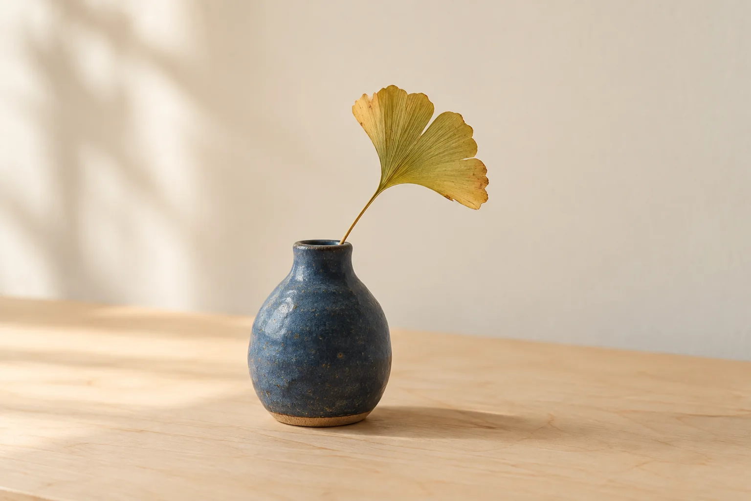 Blaue Keramikvase mit einem Ginkgoblatt